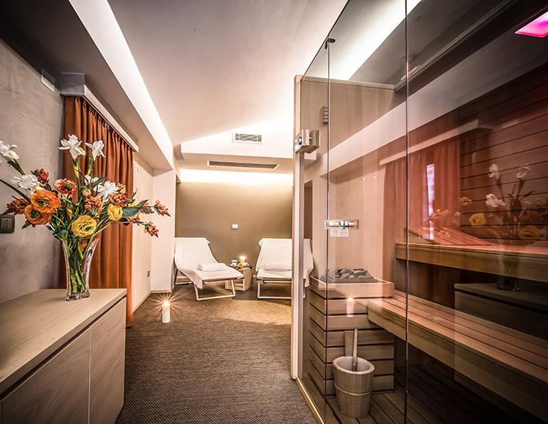 Elegante spa con sauna, fiori freschi e luce soffusa, atmosfera rilassante.