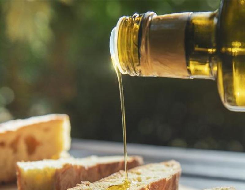 Olio dorato scivola su pane croccante, evocando calore e semplicità.